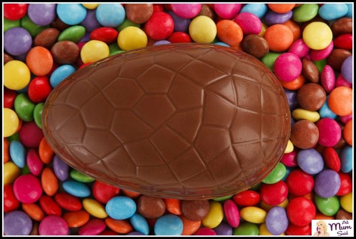Large easter egg laying on top of smarties