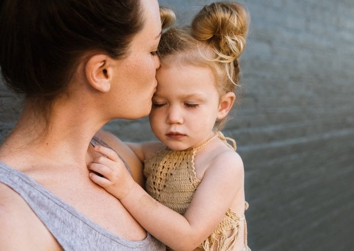 mum kissing child on forehead